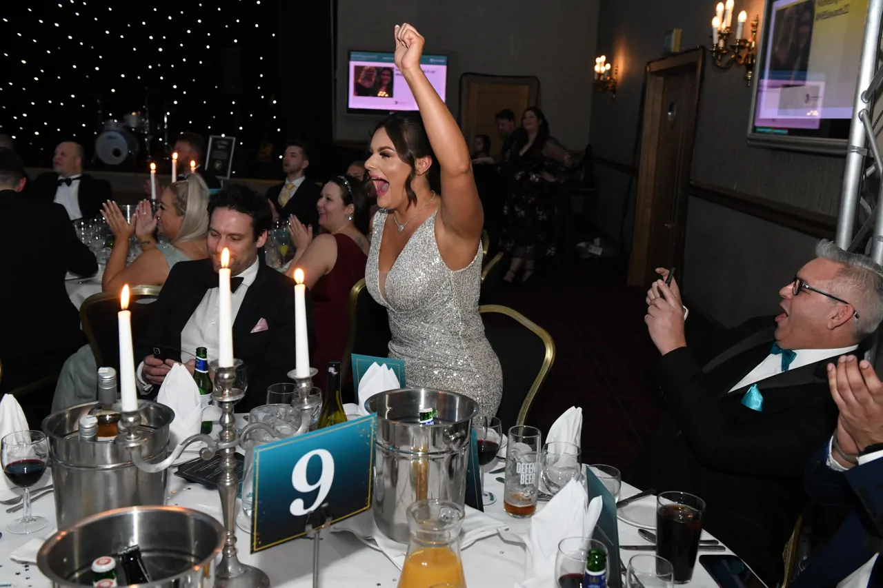 Woman standing up and cheering at awards ceremony