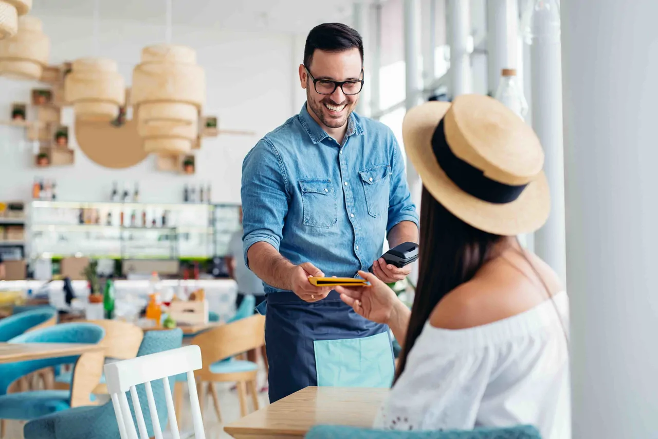 Barista smiling with customer at table