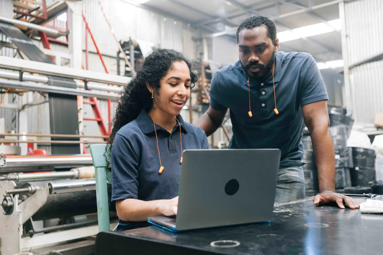 Two engineers looking at a laptop