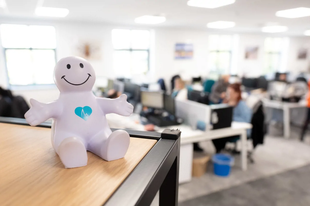 Squishy man-shaped stress ball sat on a shelf with Meridian branding on it