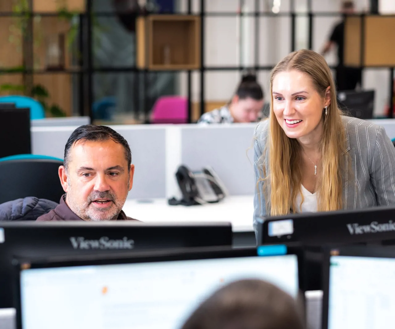 Three colleagues working in the office looking at a computer screen